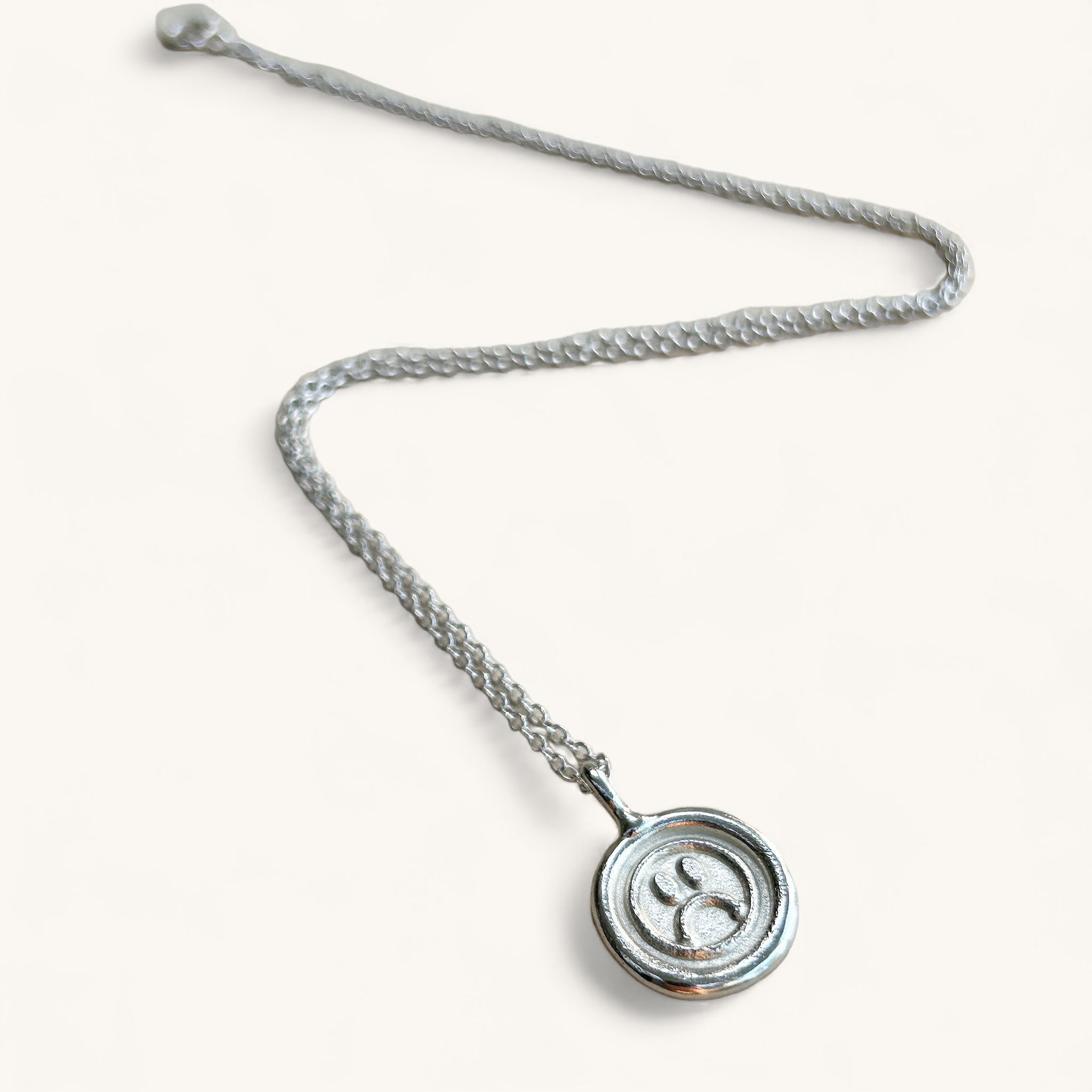 Jennifer Loiselle sad face pendant in recycled metals