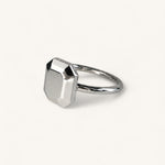 Jennifer Loiselle silver geometric ring featuring a faceted emerald  metal stone.
