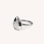 A silver ring featuring a faceted, pear-shaped metal top, handmade in London by Jennifer Loiselle 
