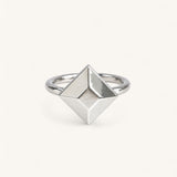 A Jennifer Loiselle silver geometric ring featuring a faceted princess-cut centerpiece with a polished band.