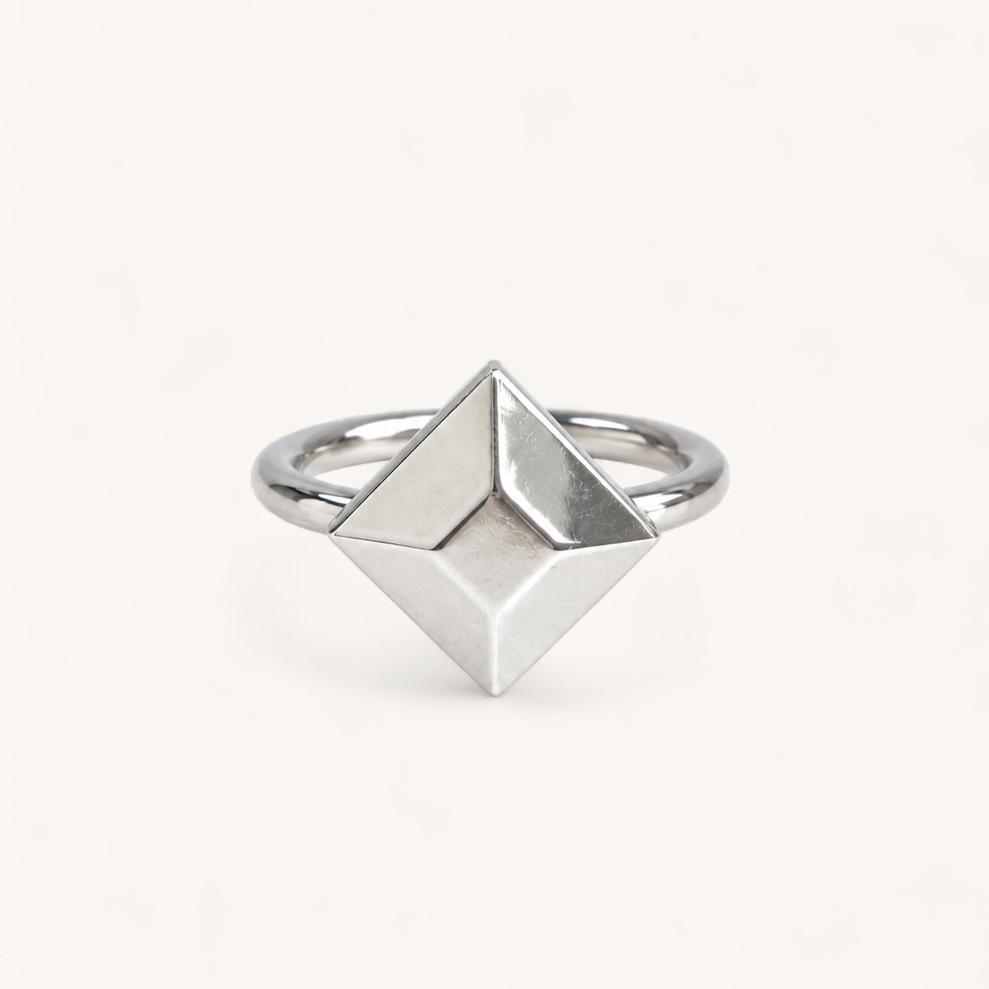 A Jennifer Loiselle silver geometric ring featuring a faceted princess-cut centerpiece with a polished band.