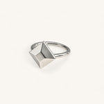 A Jennifer Loiselle silver geometric ring featuring a faceted princess-cut centerpiece with a polished band.