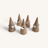Five silver rings shaped like gemstones on jewellery cones by Jennifer Loiselle