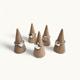 Five silver rings shaped like gemstones on jewellery cones by Jennifer Loiselle